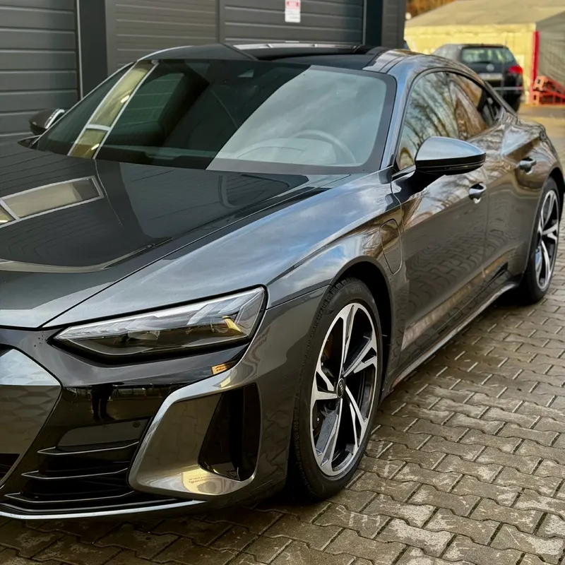 Szare Audi e-tron GT z błyszczącym lakierem przed studiem Ciach i Błysk